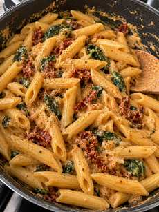 Creamy sun-dried tomato penne pasta with spinach and Parmesan cheese tossed in a rich vegetarian cream sauce.