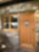 Rustic stone wall with a wooden door featuring a small window