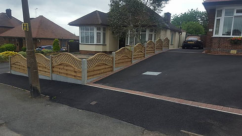 Newly paved asphalt driveway with decorative timber fencing