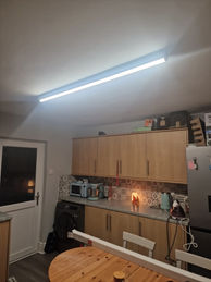 Linear LED ceiling light enhancing modern living room interior.