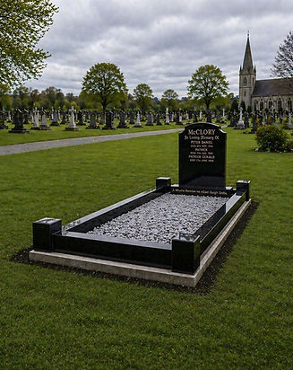 Polished black granite headstone with decorative stone-filled grave in a peaceful cemetery setting