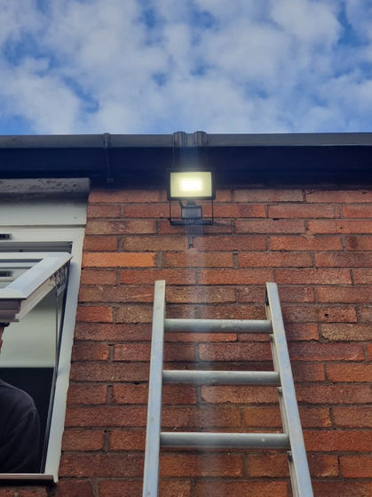 Exterior security light installation above residential property entrance.