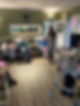 A cozy room in a care facility with four elderly individuals seated on sofas