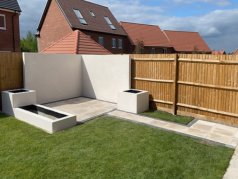 Modern landscaped garden with rendered seating area and paved patio