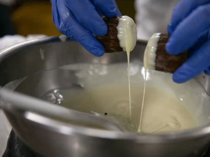 カヌレの上部にトッピングのホワイトチョコをつけている
