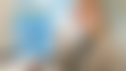 笑顔の女性がオフィスでコーヒーカップを持ち、手前にカヌレが3つ。背景に窓、大きなテキスト「ともちゃんの社食レポ」。