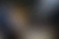 コーヒー豆を焙煎する機械を操作する焙煎士の男性。