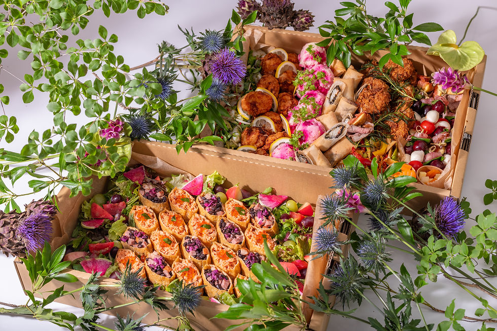 ハーブや紫の花で飾られた木箱入りの寺井幸也監修のYUKIYAMESHIケータリング料理。オープンいなりや華やかな料理写真。