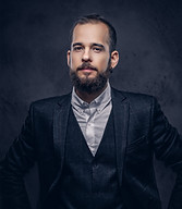 portrait-stylish-serious-bearded-male-wearing-elegant-suit-dark-background.jpg
