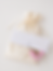 Cremefarbener Satinbeutel und Verpackung des Shirtup Stillclips als Geschenk mit rosa Blumen
