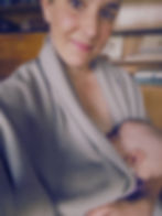 Mutter stillt ihr Baby und trägt einen Shirtup Stillponcho