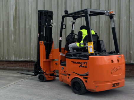 Operator using pivot steer forklift during training session outside warehouse