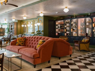 Travis Bateman Photography:  Interior lounge at Très LA Bistro with velvet seating, library shelves, and classic Parisian-inspired décor.