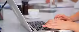 perto-do-assistente-usando-o-laptop-escrevendo-informacoes-sobre-a-reuniao-enquanto-os-med