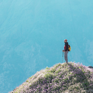 person o top of a mountain, representing overcoming trauma