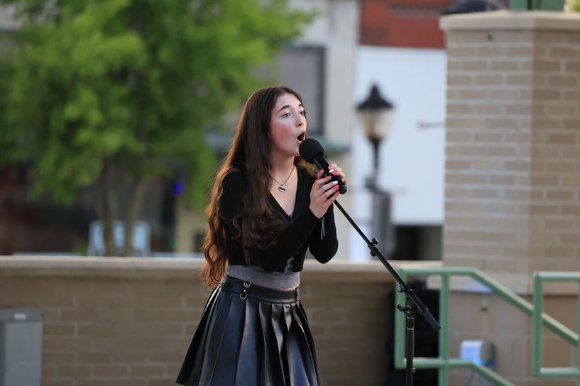 A student sings outside during a performance