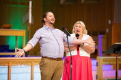 Man and woman singing on stage
