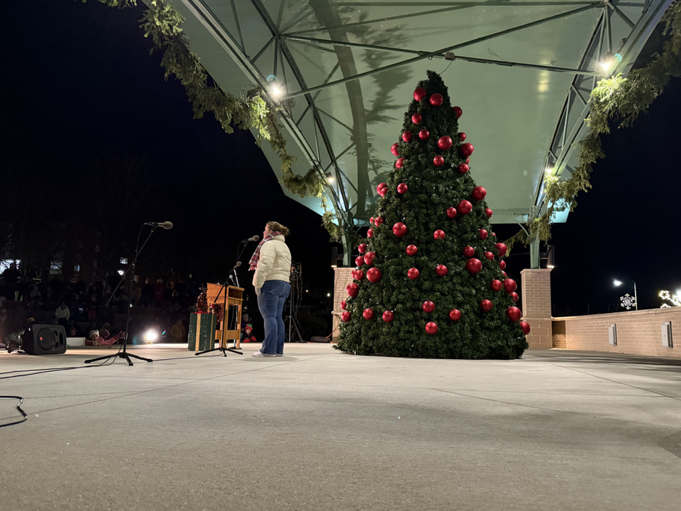 Woman talking on stage during a Christmas themed event