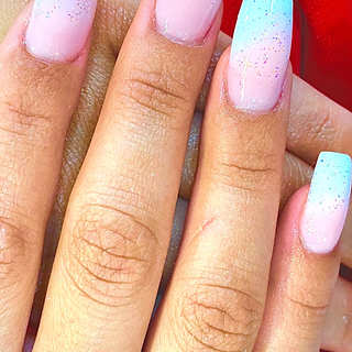 Acrylic FullSet Gel Color that is pink and blue tip with the hand cross showing off the nail with a red cloth for the background