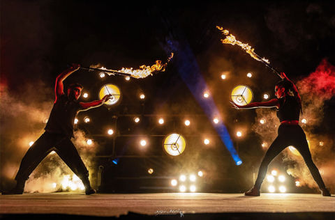 Fire artists performing with flames in an outdoor night festival