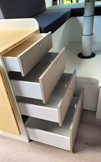 Seitenansicht der vier ausgezogenen Schubladen im Unterschrank des Küchenblocks auf Beifahrerseite im VW Crafter Individualausbau