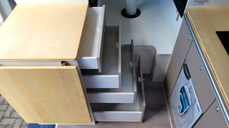 Vier ausgezogene Schubladen im Unterschrank des Küchenblocks auf Beifahrerseite im VW Crafter Individualausbau in Ansicht von oben