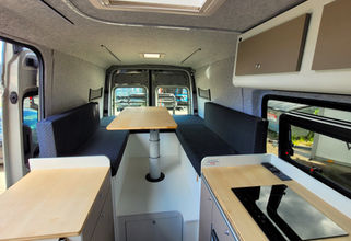 Komfortable Bett-Sitzgruppenkombi im Heckbereich als Sitzgruppe aufgebaut im VW Crafter Individualausbau
