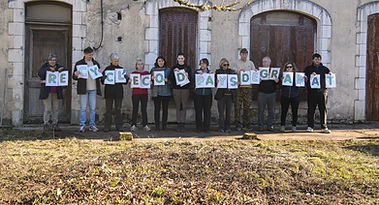 Group with RECYCLER CODA ASD GRAMAT letters in front of a building, recyclerie Gramat.