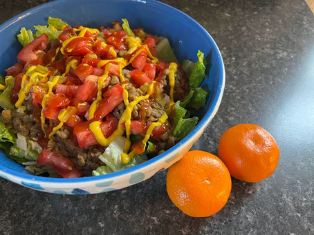 Colorful salad in a bowl, with oranges by the side
