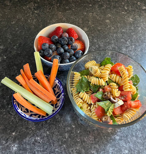 Pasta salad with a side of veggies and berries