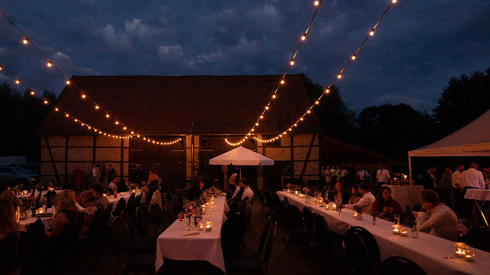 Abendaufnahme vom Innenhof des Kultourhof Raestrups mit langen Lichterketten, die über lange Tische gespannt sind