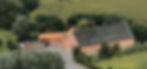 Eine Drohnen Aufnahme vom Kultourhof Raestrup inmitten von Bäumen, Feldern und Wiesen