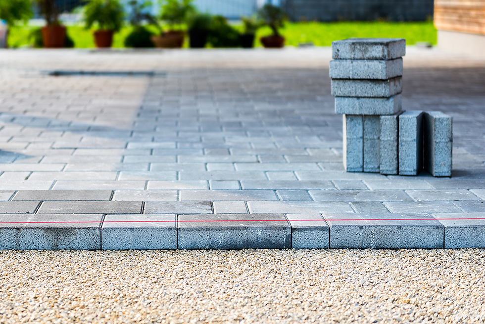 a driveway of concrete pavers being laid