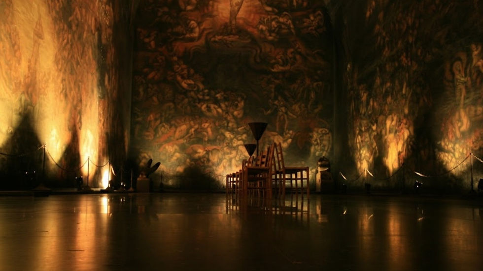 Dimly lit interior of the Emanuel Vigeland Museum in Oslo, Norway with large wall murals and a reflective floor.
