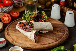 side-view-doner-kebab-wrapped-lavash-with-fresh-salad-wooden-board.jpg
