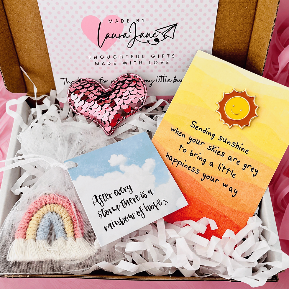 Letterbox gift containing a sunshine pin badge, sequin love heart and hanging cotton rainbow in an organza bag.