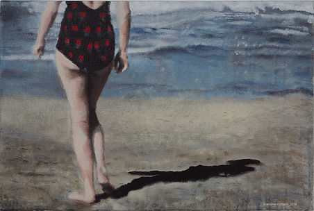 Eine Frau steht am Strand, umgeben von Licht und Schatten. Sie trägt ein getupftes Badekleid, das im Sonnenlicht leuchtet. 