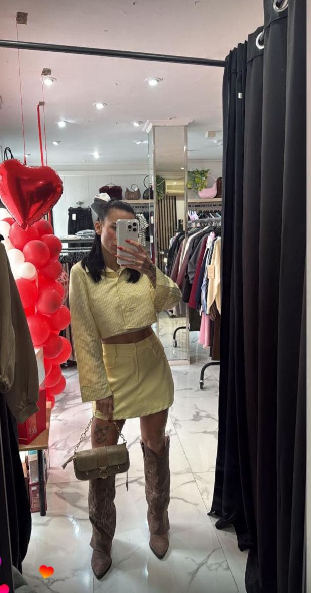 Mujer en camisa clara y falda, botas altas