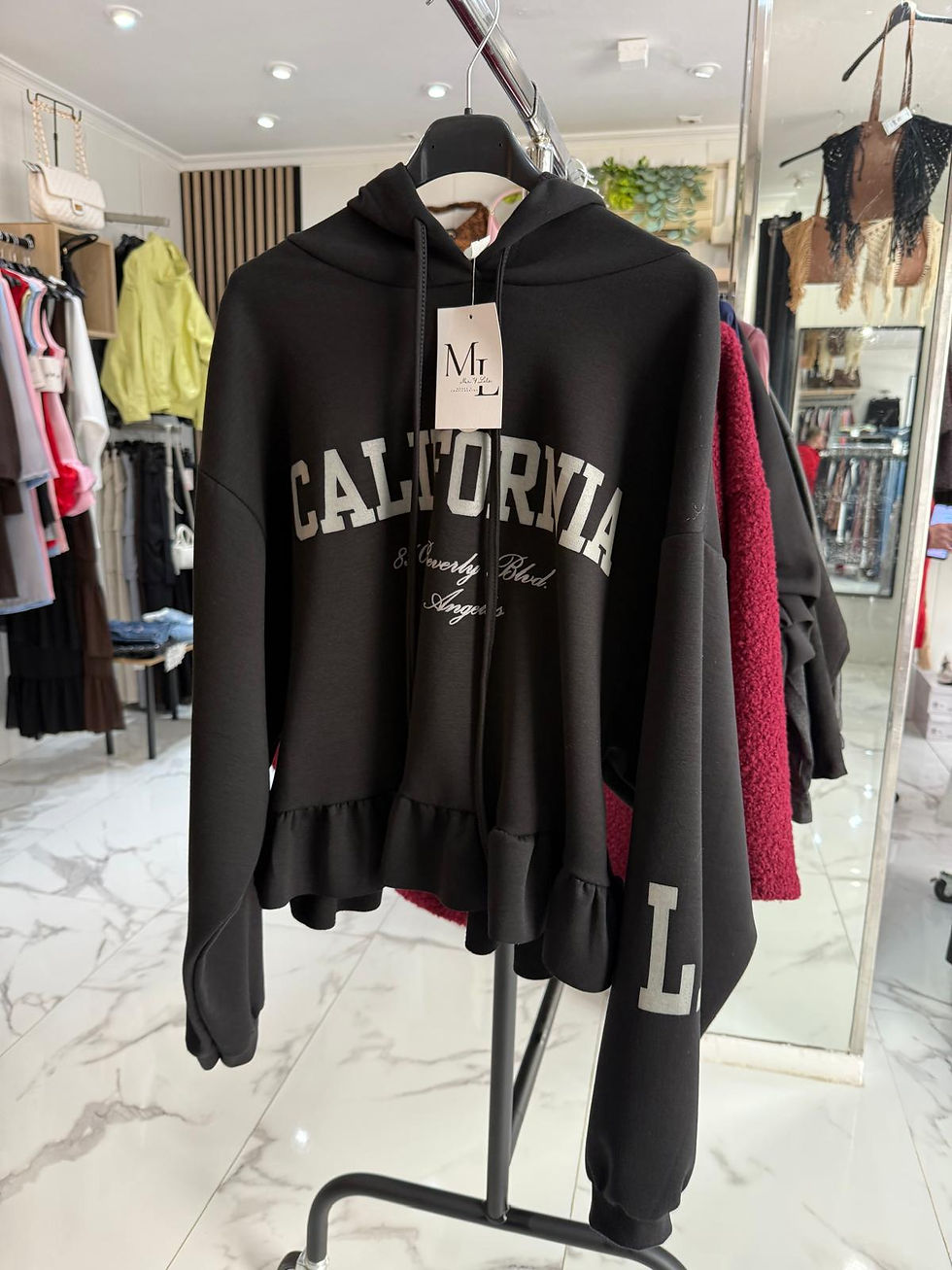 Sudadera negra con capucha, texto CALIFORNIA y bajo volante