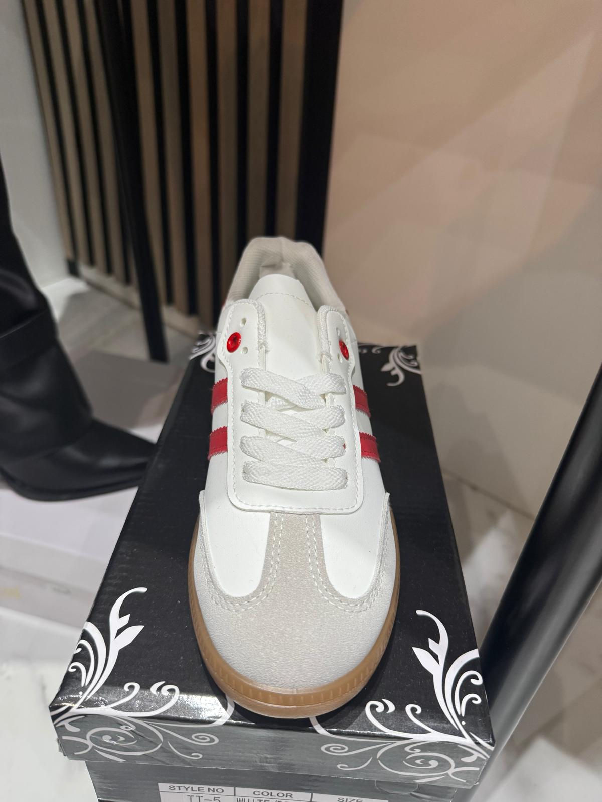 Zapatilla blanca con rayas rojas y suela marrón
