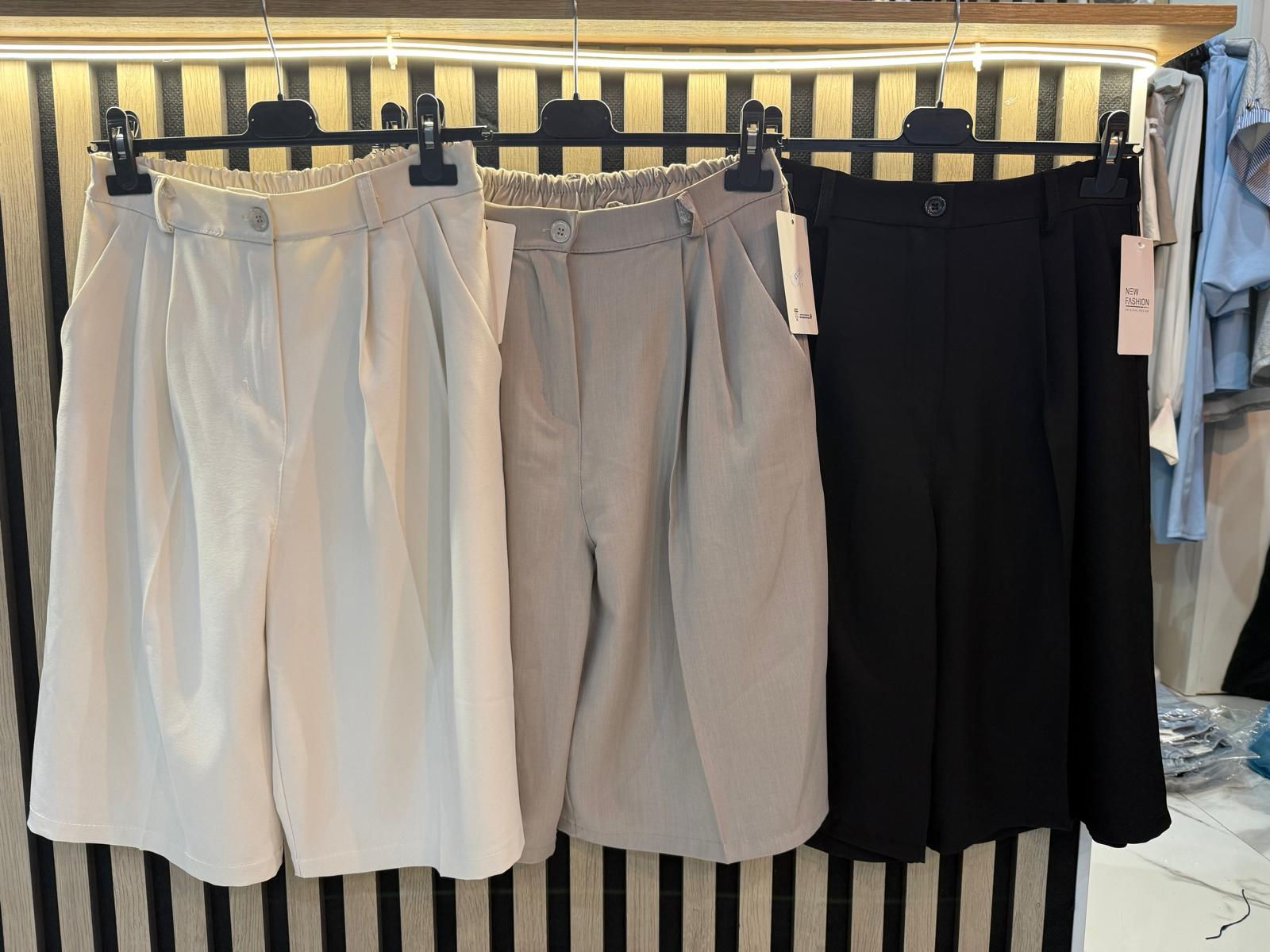 Pantalones cortos plisados en blanco, gris y negro.