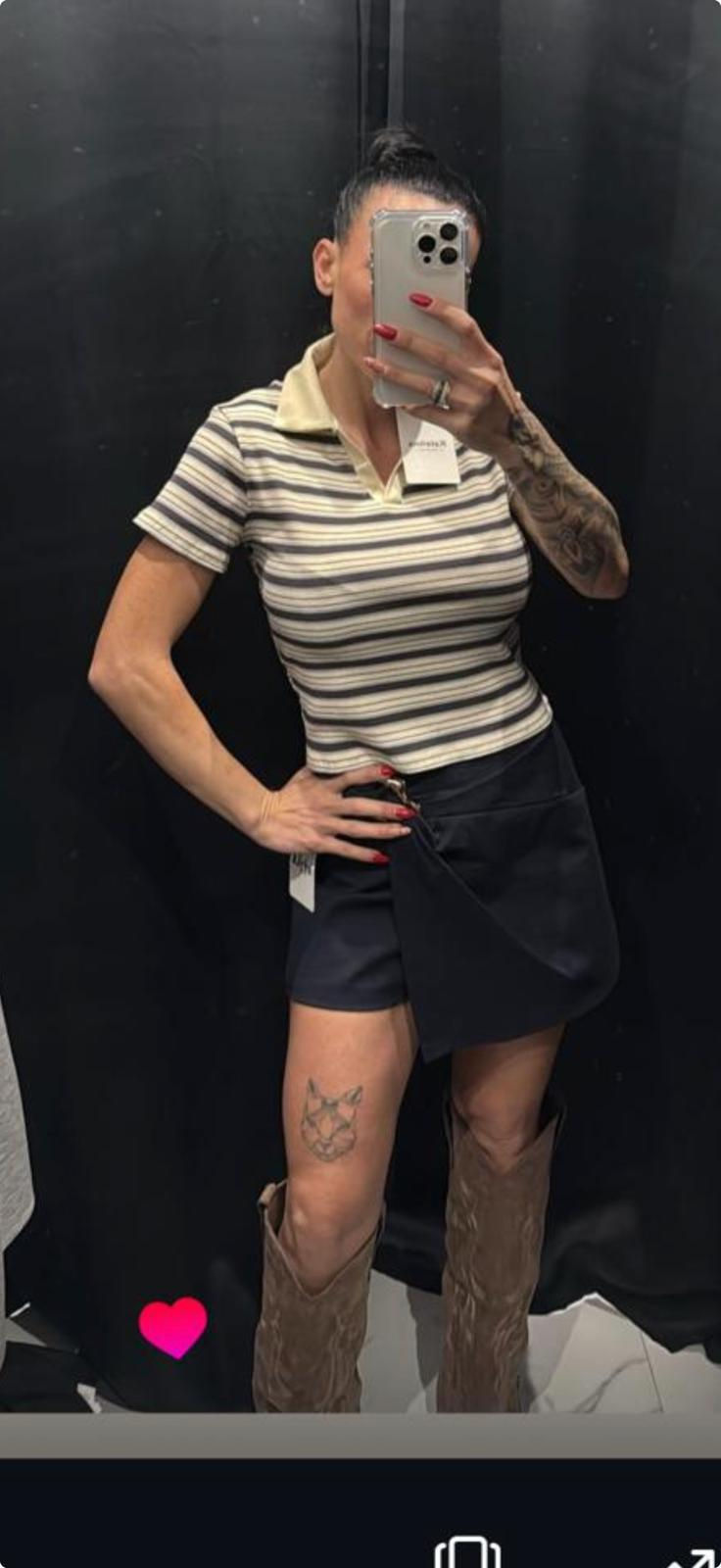 Mujer con camiseta polo a rayas y falda oscura