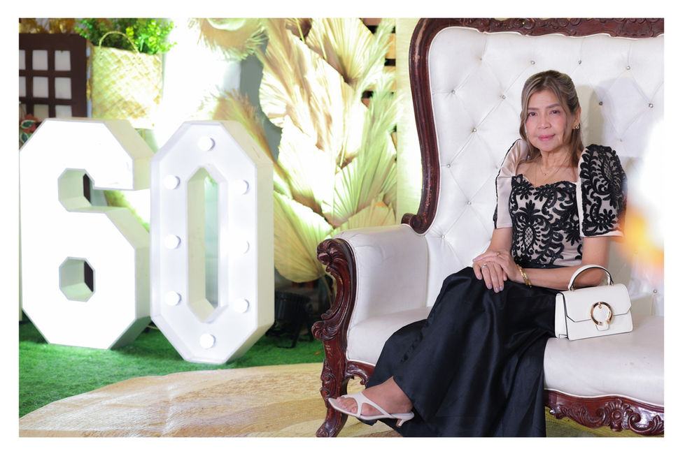 a woman in a black dress sits in a white chair