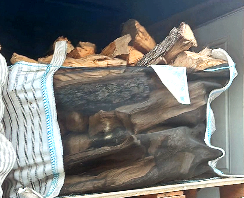 Bulk bag filled with seasoned hickory firewood logs.