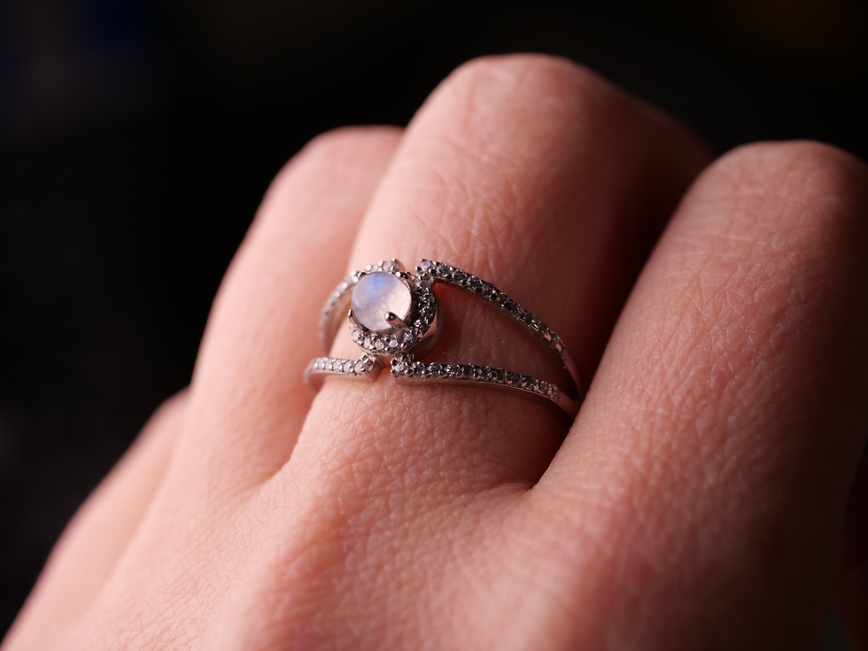 Thumbnail: A breathtaking moonstone ring showcasing a radiant central stone encased in a sparkling halo of cubic zirconia on a polished