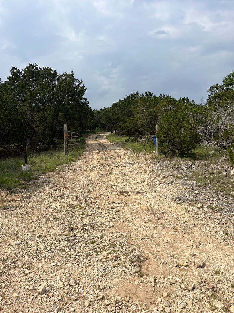 A heavily eroded gravel driveway in Leander Texas