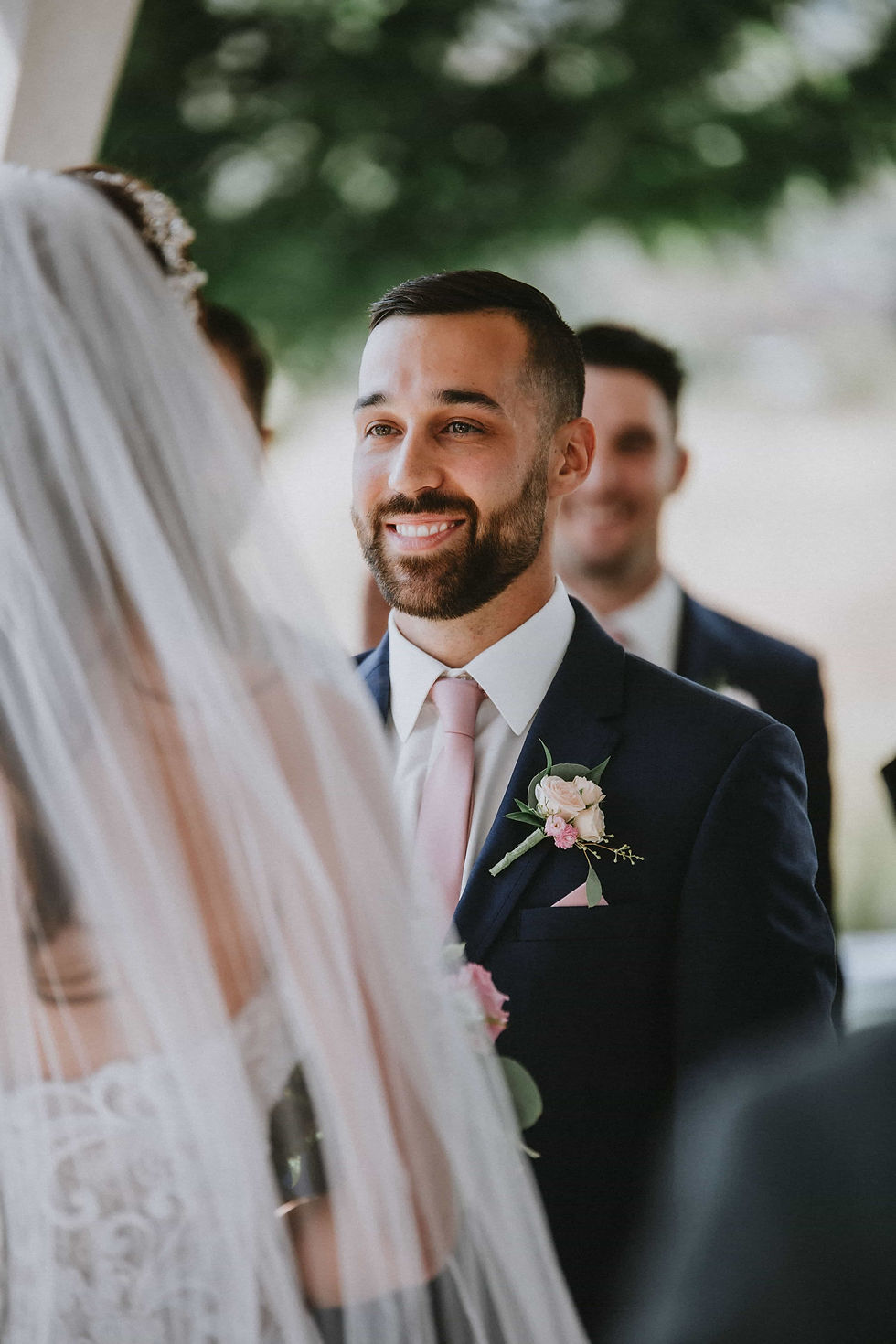 Groom smiling at his bride to be