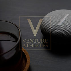 Coffee and a rock with Venture Athletes logo and text on table
