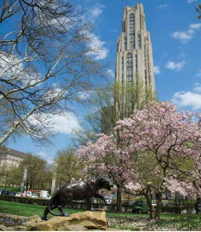 Cathedral of Learning and a panther statue on the campus of the University of Pittsburgh in the spring.