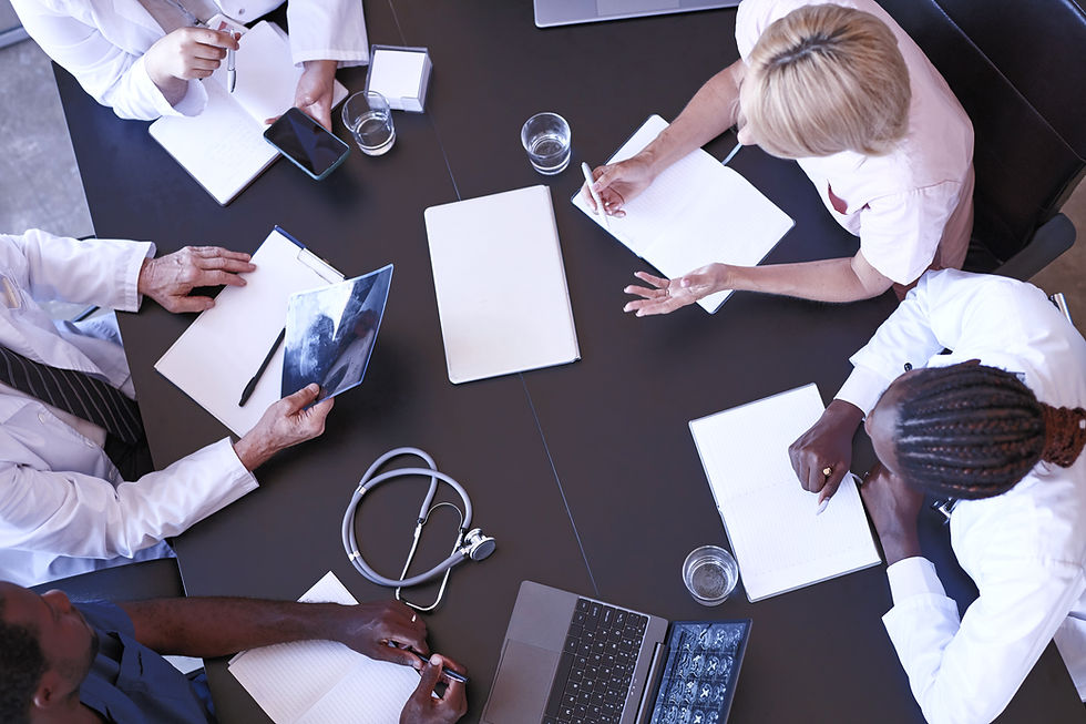 Medical professionals having a consultation around a boardroom table.